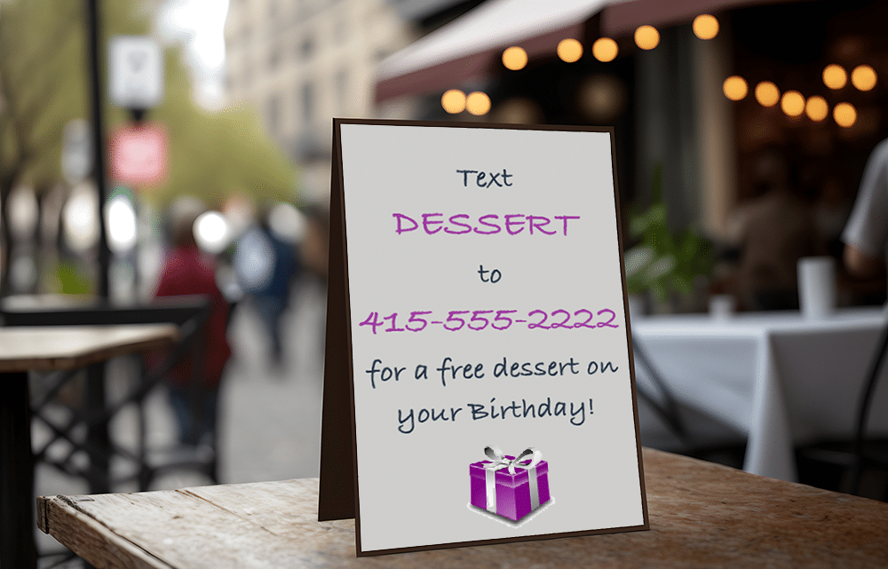 A tabletop ad at a restaurant offering a free birthday dessert for restaurant text message opt-ins