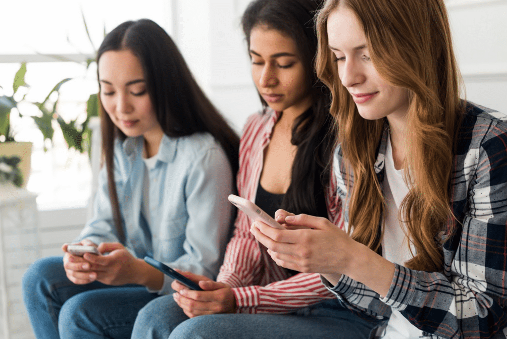 Three women looking at their mobile phones