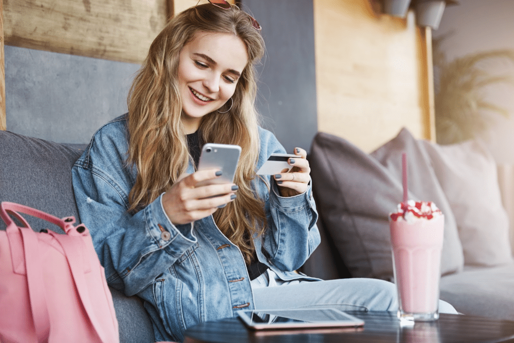 Woman holding a credit card looking at her phone