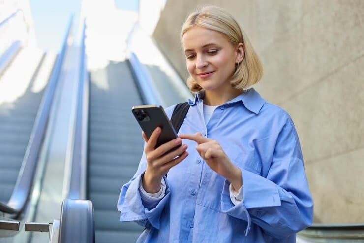 woman looking at her phone and smiling