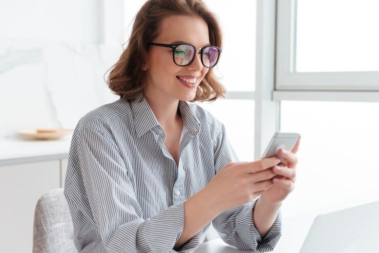 woman looking at her phone and smiling