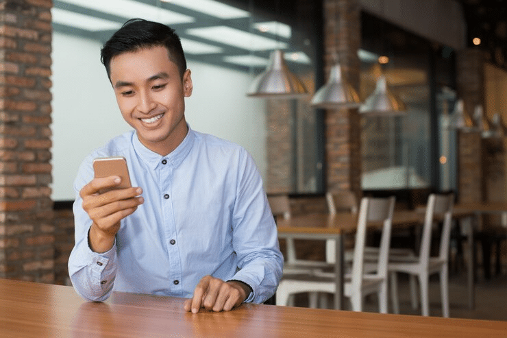 man looking at a phone and smiling