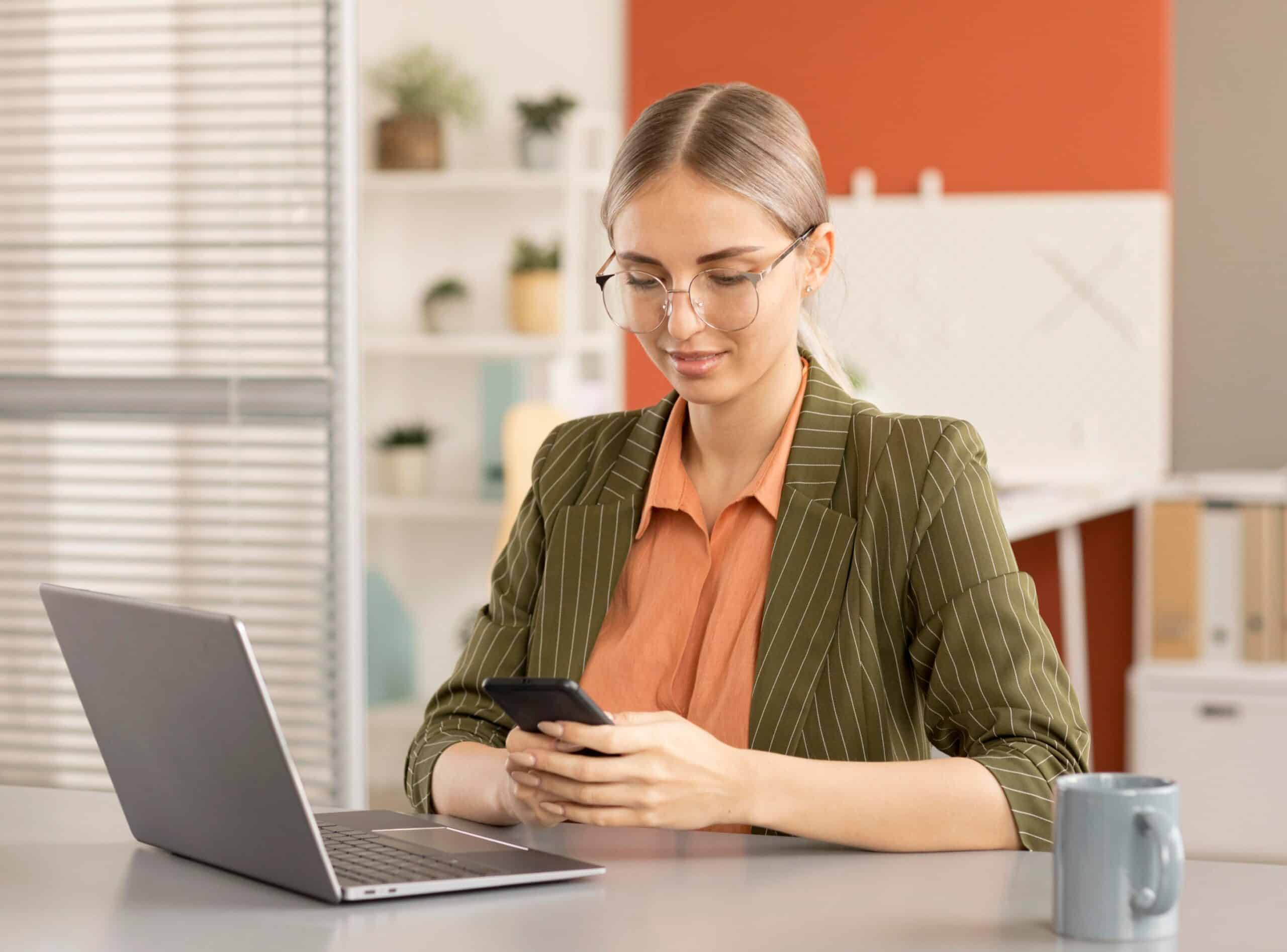 woman with an eyeglass holding a phone