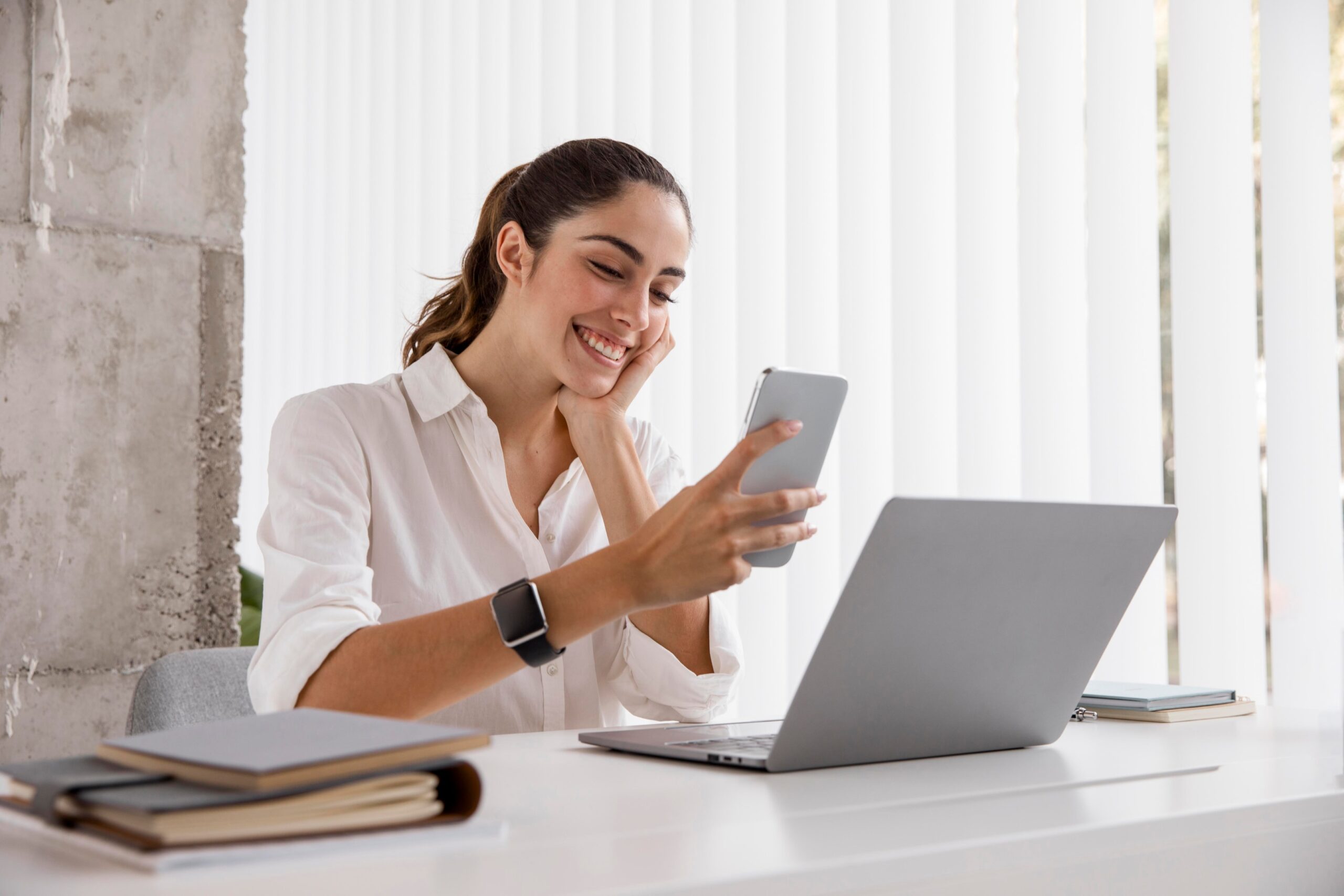 A girl holding a phone while smiling