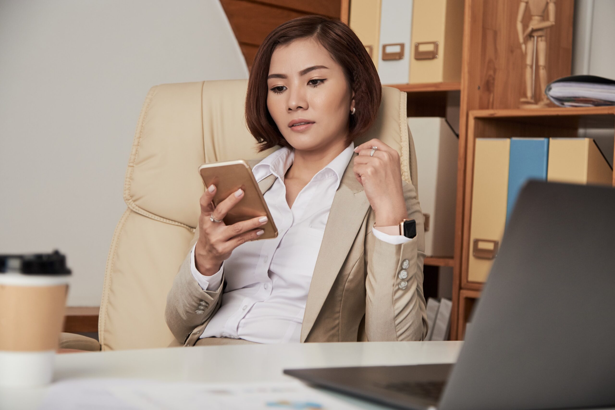 Woman sitting on a chair while holding a phone