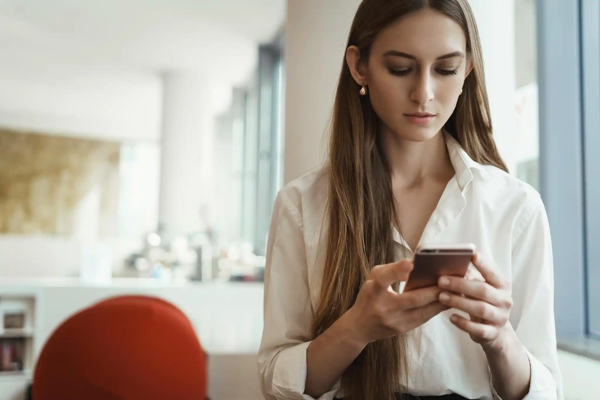 Woman using an AI assistant on her phone in an office setting